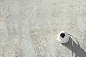 Modern CCTV security camera on stone building wall outdoors. Space for text