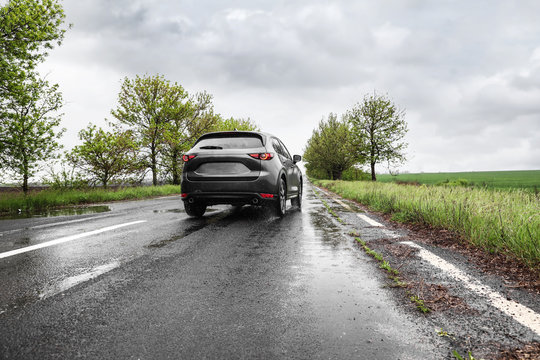 Wet Suburban Road With Car On Rainy Day