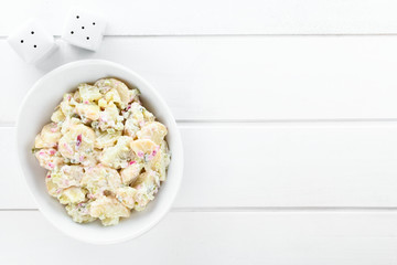 Fresh homemade vegetarian potato salad made with red onion, pickles, mayonnaise and mustard, served...
