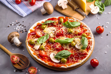Making homemade pizza from dough with mushrooms, tomatoes and cheese