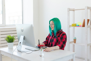 Creative, illustrator and designer concept - happy woman with green hair is drawing a project