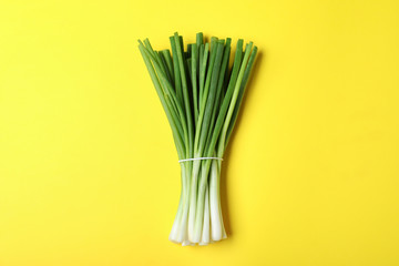 Bunch of fresh green onion on yellow background