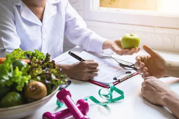 Fotobehang Voedingsdeskundige die patiënt overleg geeft met gezonde groenten en fruit, juiste voeding en dieetconcept © Kittiphan