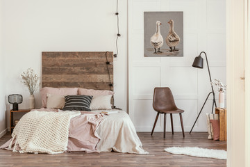 Black and white pillow on pastel pink and beige bedding