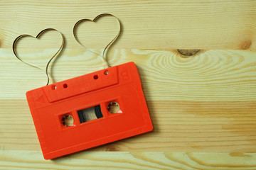 Red cassette tape audio with label tape ribbon heart shape on wooden floors with Copy space,...