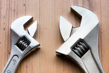 Adjustable wrenches on wooden background