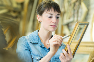 woman restoring an antique frame