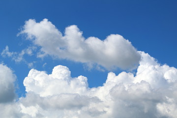Fototapeta na wymiar White dense cumulus clouds on a bright sunny day against the blue sky.