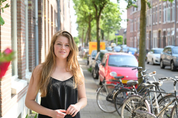 Fototapeta na wymiar Dutch student girl walking through a local street in Amsterdam
