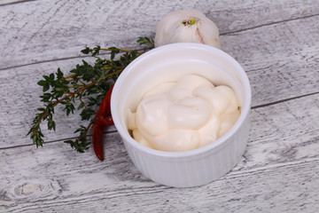 Mayonnaise sauce in the white bowl served thyme and garlic