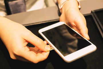 Employees are putting nano-SIM cards in the store for customers to buy women hands.