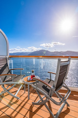 Refreshing drink on a balcony  with outdoor chairs and table on a cruise vacation. Sea background.