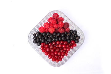 set of fresh berries of currant and raspberry in a plate on a white background. isolated berries
