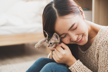 Young Asian woman holding and playing with her cute kitten cat with lovely moment, pet and human...