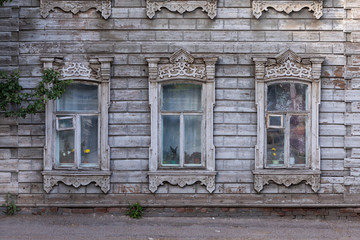 Fototapeta na wymiar Old house with wooden shutters in Russia. Facade of a vintage house with blue gray walls