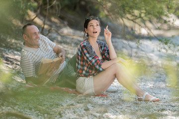 happy couple relaxing on river bank