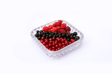 set of fresh berries of currant and raspberry in a plate on a white background. isolated berries