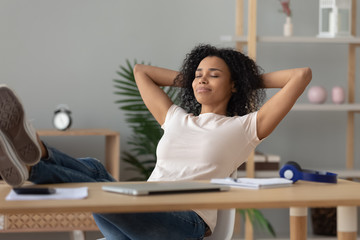 Happy african girl student relaxing finished study sit at desk