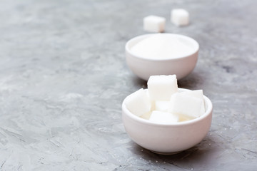 Concept advantages of refined sugar over granulated sugar. Two types of sugar in white bowls on the table, standing next to each other
