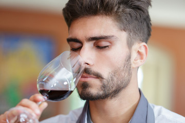 Fototapeta na wymiar portrait of happy man tasting wine in winery
