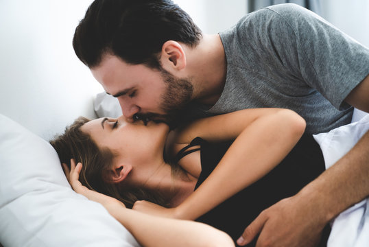 Cute couple relaxing on bed and kissing , love and relationships concept.