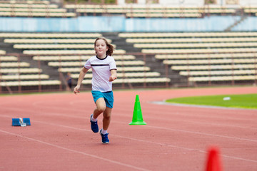 Child running in stadium. Kids run. Healthy sport.