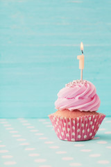 birthday caucpcake on blue wooden background
