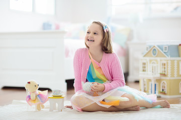 Obraz na płótnie Canvas Little girl playing with doll house. Kid with toys
