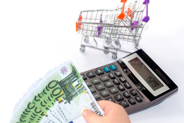 Euro banknotes with calculator and shopping basket background. - 277238006