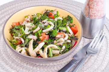 Salad of lettuce leaves, tomatoes and squid. 
