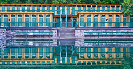 A historic natural thermal pool in Bad Fischau, Austria. Build in 1898 and the yellow-green wooden...