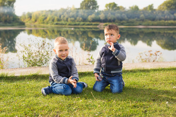 Children, childhood, people concept - Kids boys playing on a beach near river