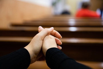 Close up of a woman hands praying at the church