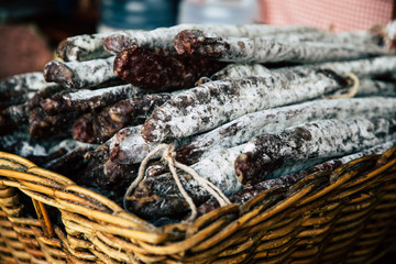 Dry meat salami or sausage on wicker basket