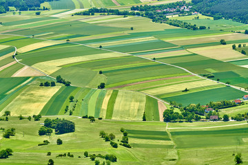 Fields, forest and roads building nice patterns. Wheat is not ripe yet, therefore a lot of green color. As seen from Hohe Wand, Austria.