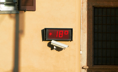Street thermometer displaying temperature of 18 degrees.