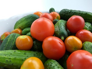 Food photo, red tomatoes and green cucumbers on white background
