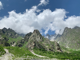 Fototapeta na wymiar Russia, North Ossetia - Alania. The tops of the mountains framing Tsey (Tseyskoe, Tseyskoye) gorge in sunny June day