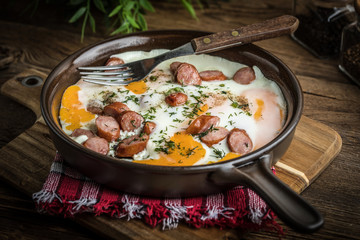 Tasty cooked egg with chopped sausages.