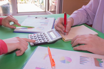 Business people are using calculator to work. Young Business people Calculating Finance Bills In...