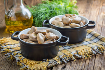 Broad beans served in black bowls.