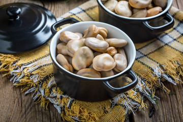 Broad beans served in black bowls.