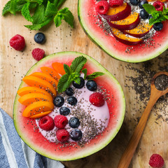 Healthy summer breakfast with fruit salad and yogurt in watermelon