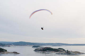 Paraglider gliding over an ice cold fjord.
