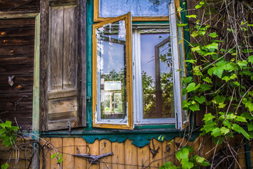 Fototapeta na wymiar Abandoned wooden building with a broken window