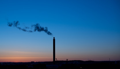 Smoke from a power plant chimney at sunset.