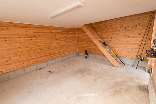 Almost Empty Room With Wooden Walls And Stairs.