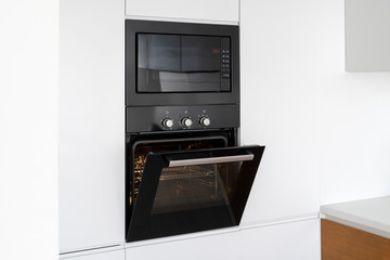 Modern built in oven with open glass door on white kitchen