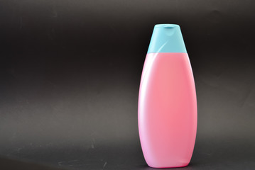 A bottle of household chemicals cosmetics on a black background neck of a bottle close up macro...
