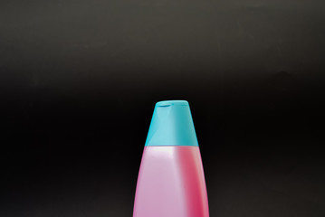 A bottle of household chemicals cosmetics on a black background neck of a bottle close up macro...